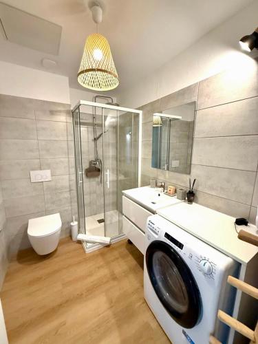 une machine à laver dans une salle de bain avec douche dans l'établissement Cala Rossa by Saraï, Apt T2 4 personnes, dans Résidence hôtelière avec piscine, à Lecci
