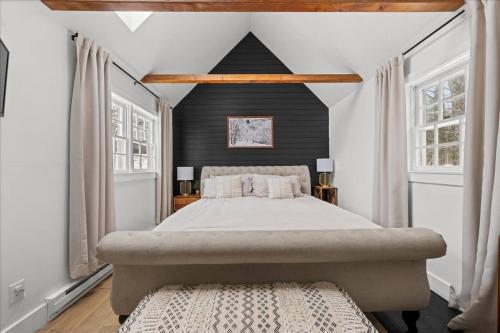 a bedroom with a large bed and two windows at Jericho Mountain Lodge in Glen
