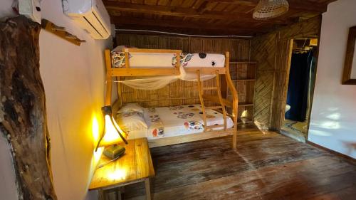 a room with a bunk bed and a table at Hostal Olmito Canoa in Canoa