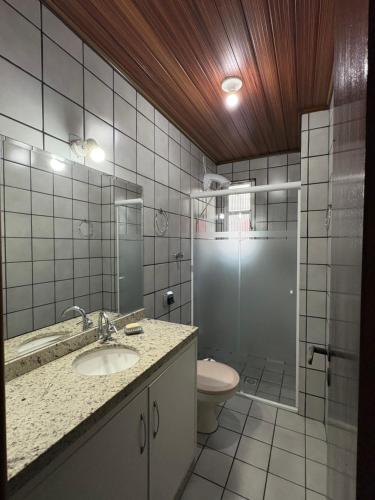 a bathroom with a toilet and a sink and a shower at Lindo apartamento super completo em Meia Praia, 100 metros do mar e 10 quadras do centro in Itapema