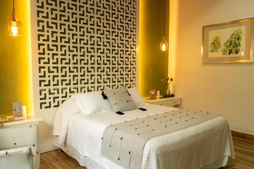 a bedroom with a white bed and yellow walls at Hotel Casa Vertiz in Oaxaca City