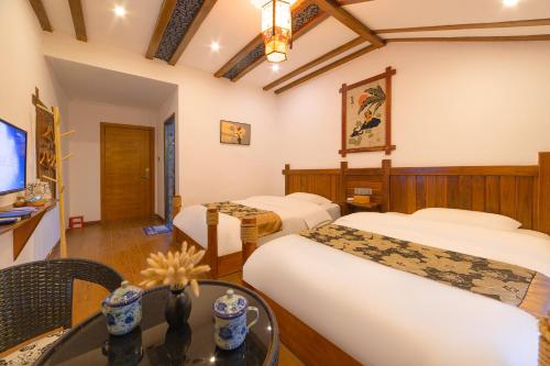 a hotel room with two beds and a table at 张家界星河清梦民俗客栈 in Zhangjiajie