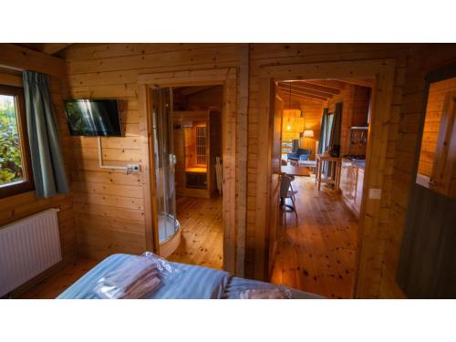 Cabaña de madera con dormitorio y cocina en Lodge in Markelo with Sauna and Pool Nearby, en Markelo