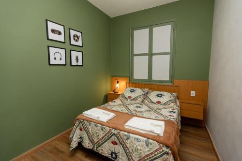 a green bedroom with a bed and a window at Casa Festival - Caminhos de OP in Ouro Preto