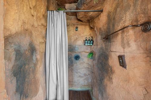 una doccia con una tenda in un muro di pietra di Southwest Silo Stay- 1 Bedroom Near Zion & Bryce a Cane Beds