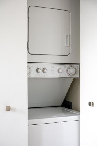 a washer and dryer with a mirror above it at Driftwood Dreams 1B in Traverse City