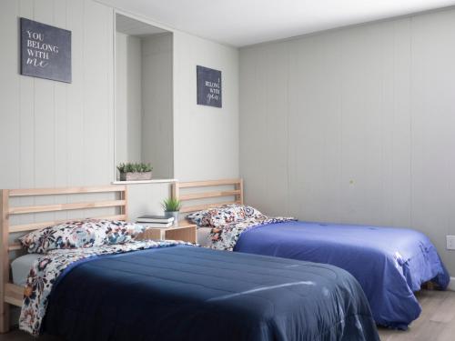 two beds in a room with blue comforter at Guest House Baltimore County Parkville in Parkville
