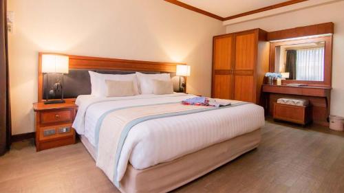 Postel nebo postele na pokoji v ubytování Tohsang Heritage Ubon Ratchathani Hotel