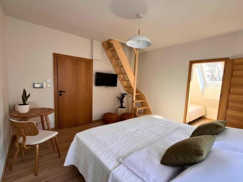a bedroom with a large bed and a staircase at Dom Przy Czerwonym Szlaku - The Red Trail Cottage in Cisiec