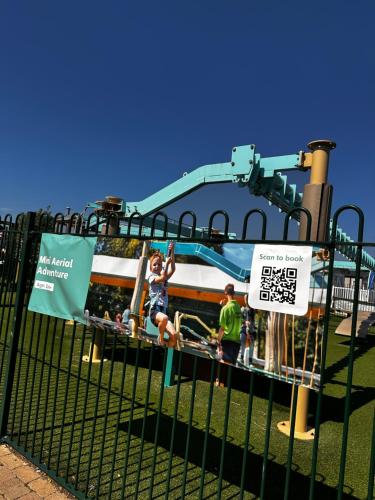 a girl on a swing at an amusement park at The Aurora van at Presthaven sands holiday park and beach resort in North Wales- 8 berth in Prestatyn