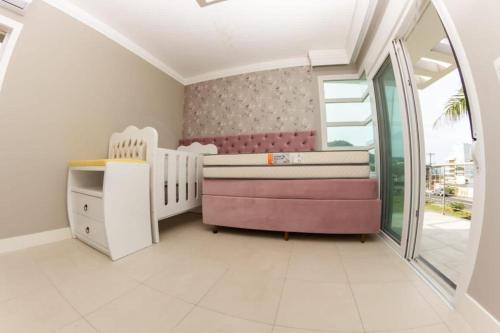 a childs room with a crib and a bed and a window at Casa deslumbrante, com vista para o mar in Camboriú