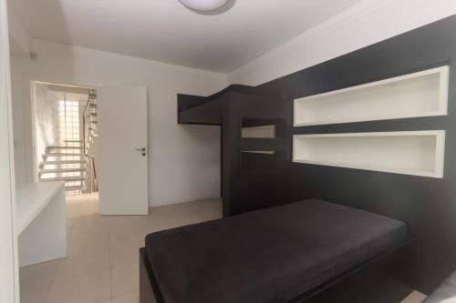 a bedroom with a black bed in a room at Casa deslumbrante, com vista para o mar in Camboriú