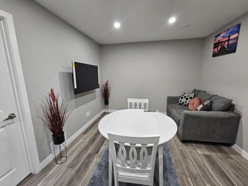 a living room with a white table and a couch at Serene Private Basement Suite in Regina in Regina