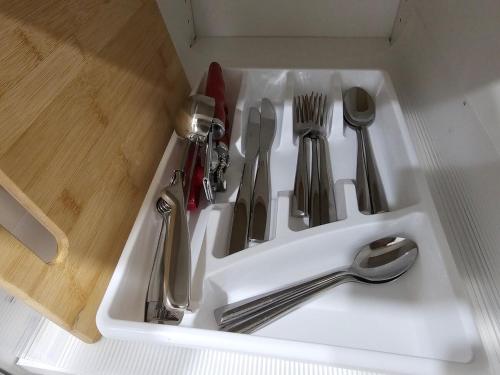 a white sink with utensils in it at Serene Private Basement Suite in Regina in Regina