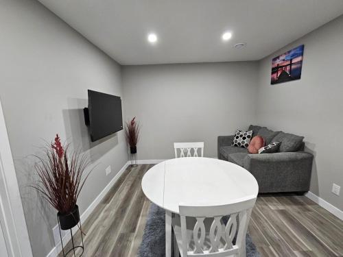 a living room with a white table and a couch at Serene Private Basement Suite in Regina in Regina