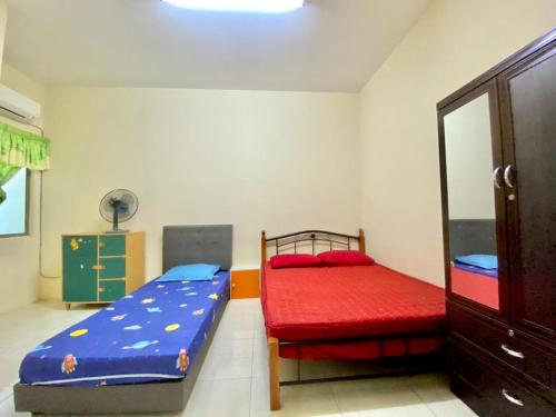a bedroom with two beds and a red mattress at Homestay Ipoh Maziah in Ipoh
