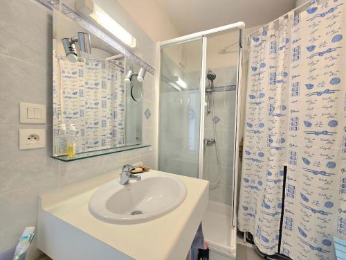 une salle de bain blanche avec un lavabo et une douche dans l'établissement Appartement 2 pièces face mer, balcon, 50m plage, proche centre et commerces - Saint-Brévin - FR-1-364-141, à Saint-Brévin-les-Pins