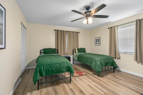 a bedroom with two beds and a ceiling fan at Near Beaches, Downtown Melbourne, MLB Airport, FIT, and HRMC! 1 in Melbourne