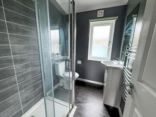 a bathroom with a shower and a toilet and a sink at Cosy Chalet On A Beautiful Holiday Park In Lowestoft Ref 12080B in Lowestoft