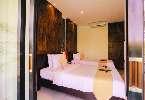 two beds in a hotel room with white sheets at Angkor Home 27 in Phumĭ Réach Born