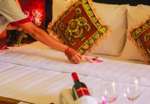 a person is putting a flower on a bed at Angkor Home 27 in Phumĭ Réach Born