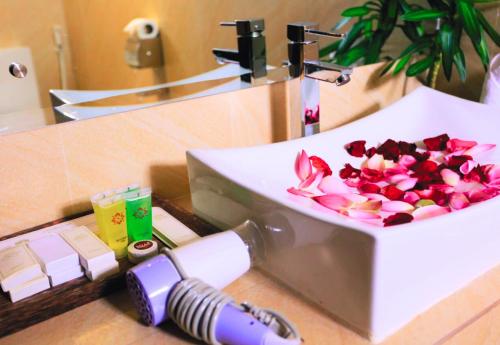 a bathroom with a sink with flowers in it at Angkor Home 27 in Phumĭ Réach Born