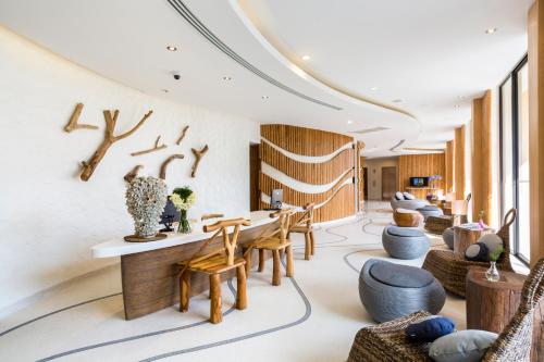 a lobby with chairs and a table and a room with logs at Bandara Phuket Beach Resort in Panwa Beach