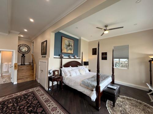 a bedroom with a large bed and a ceiling fan at 2 Rivers Inn The Thousand Islands - LUXURY WATERFRONT WALKOUT in Gananoque