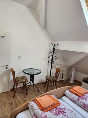 a room with two beds and a table and chairs at Gasthaus Hochwald in Hattgenstein