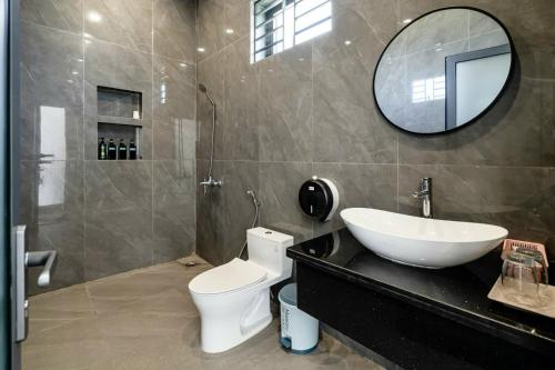 a bathroom with a sink and a toilet and a mirror at Parkview Villa Long Hai in Long Hai