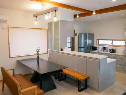 a large kitchen with a table and a whiteboard at Vacation House YOKOMBO ANNEX in Naoshima