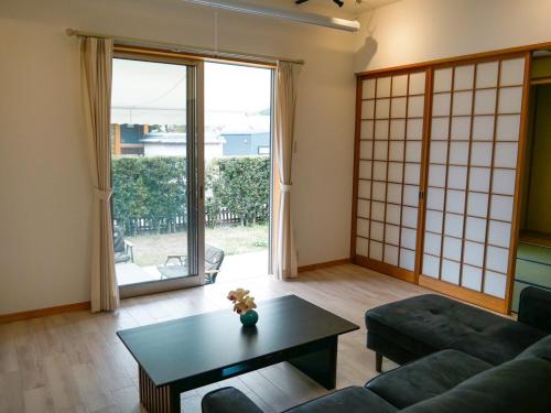 a living room with a couch and a table at Vacation House YOKOMBO ANNEX in Naoshima