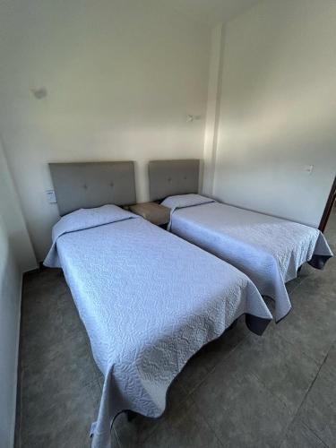 two beds in a room with blue blankets at Tritón Apartment, ground floor and pool in Barra de Navidad