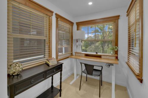 a home office with a desk and two windows at Near All Things SD - Canyonview - Jacuzzi - EV Charge in San Diego