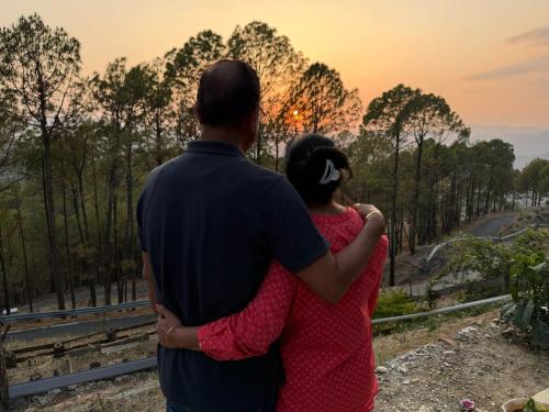 a man and a woman looking at the sunset at In the woods homestay Lansdowne in Lansdowne