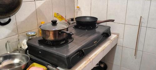 Unas ollas y sartenes encima de una estufa en Rumah Sedana, en Ubud