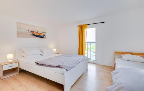 a white bedroom with two beds and a window at Nice Home In Zadrkovec With Wifi in Zadrkovec