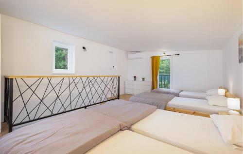 two beds in a bedroom with white walls at Nice Home In Zadrkovec With Wifi in Zadrkovec