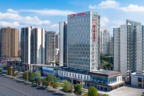a large city with tall buildings and trees at Hilton Garden Inn Leshan Shizhong in Leshan