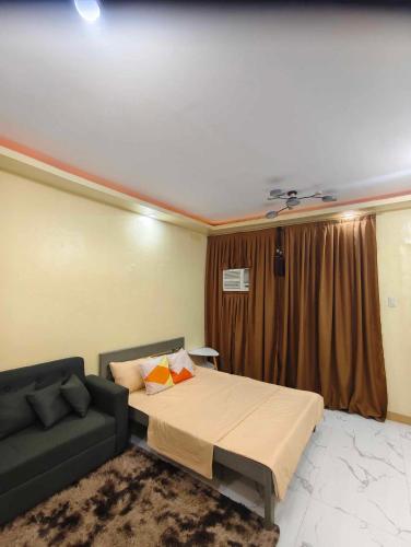 a bedroom with a bed and a couch at sjltransienthouse in General Santos