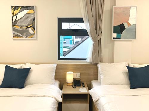 a hotel room with two beds and a window at Ngo - The Gallery Hotel Dalat in Da Thanh
