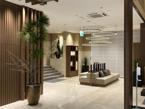 a lobby with a couch and a potted plant at Onomichi Kokusai Hotel in Onomichi