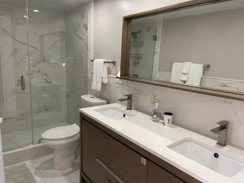 a bathroom with a sink and a toilet and a mirror at Sunset Beach 101 Beach Front Unit in Holmes Beach