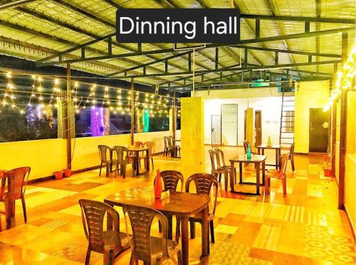 a dining hall with wooden tables and chairs at Greens home stay in Yelagiri