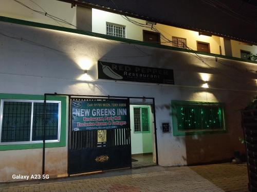 a building with a sign for a new greens inn at Greens home stay in Yelagiri