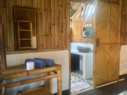 a bathroom with a sink in a wooden room at AlBambu in Gili Air