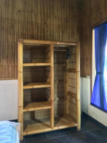 a bird cage in a room with a window at AlBambu in Gili Air