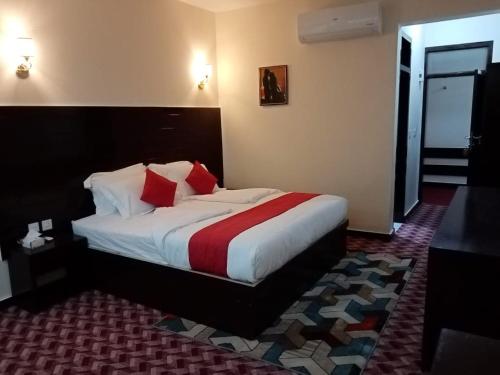 a hotel room with a bed with red and white pillows at Hunza Roof Hotel in Hunza