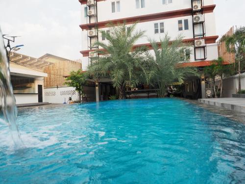 a large blue swimming pool in front of a building at Activate C3 Hostel in Phnom Penh