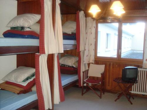 Cette chambre comprend 4 lits superposés et une télévision. dans l'établissement Studio Courchevel Moriond, 26 m², 2 pers, centre station - FR-1-514-76, à Courchevel